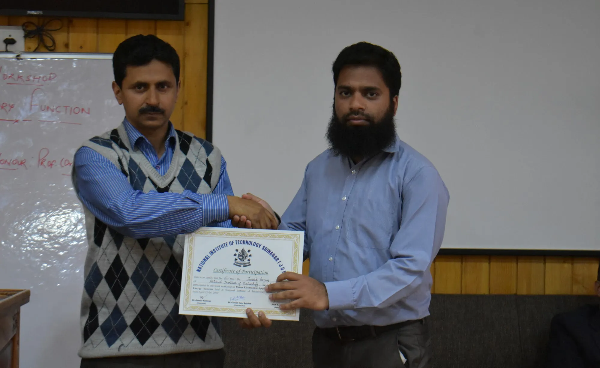 Junaid Farooq receiving a certificate from Prof. A. H. Bhat